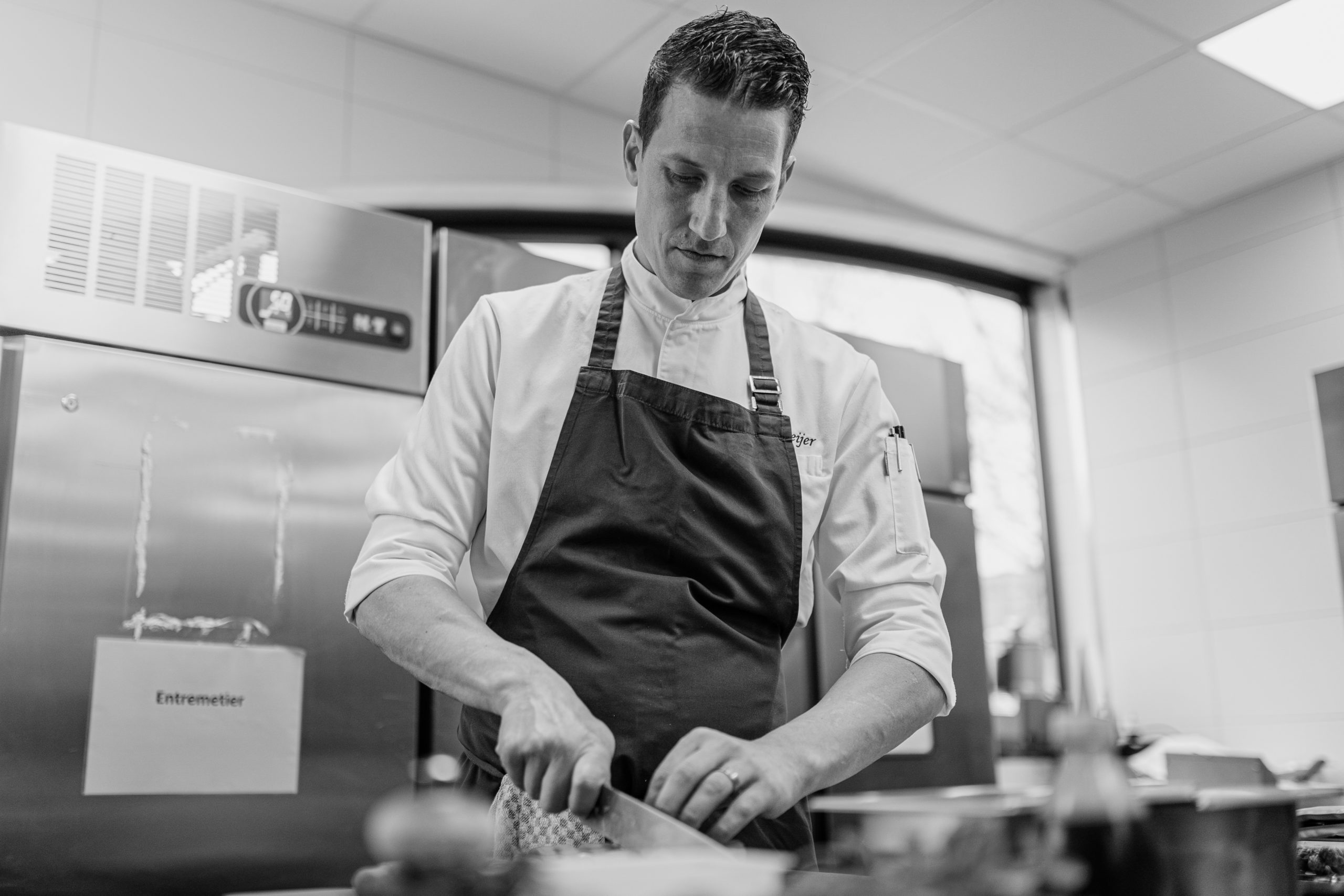 Küchenchef bereitet Fleisch vor im Glashaus Restaurant Köln. 