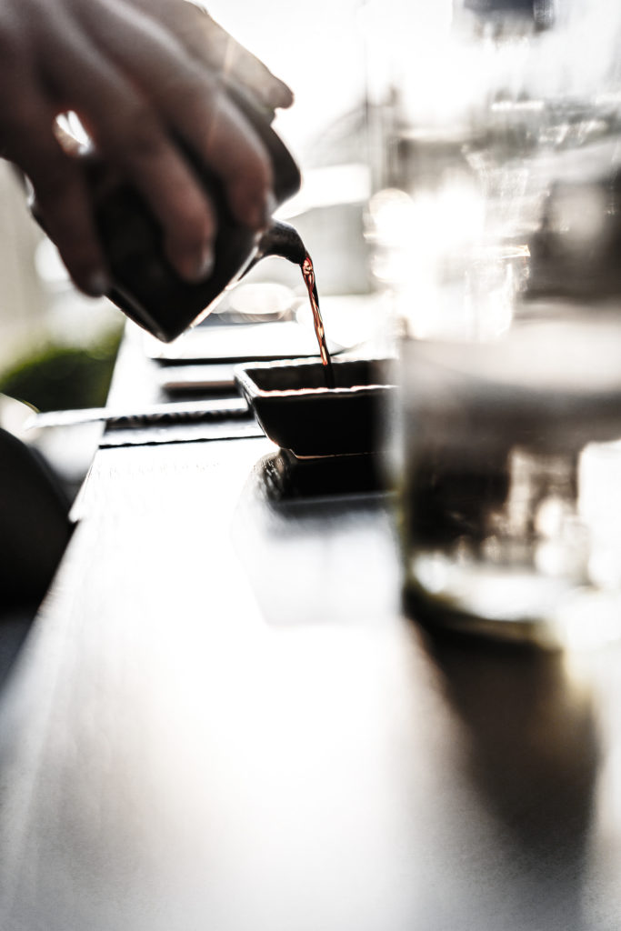 Soy sauce is poured into a small bowl on the table in the Glashaus restaurant in Cologne.