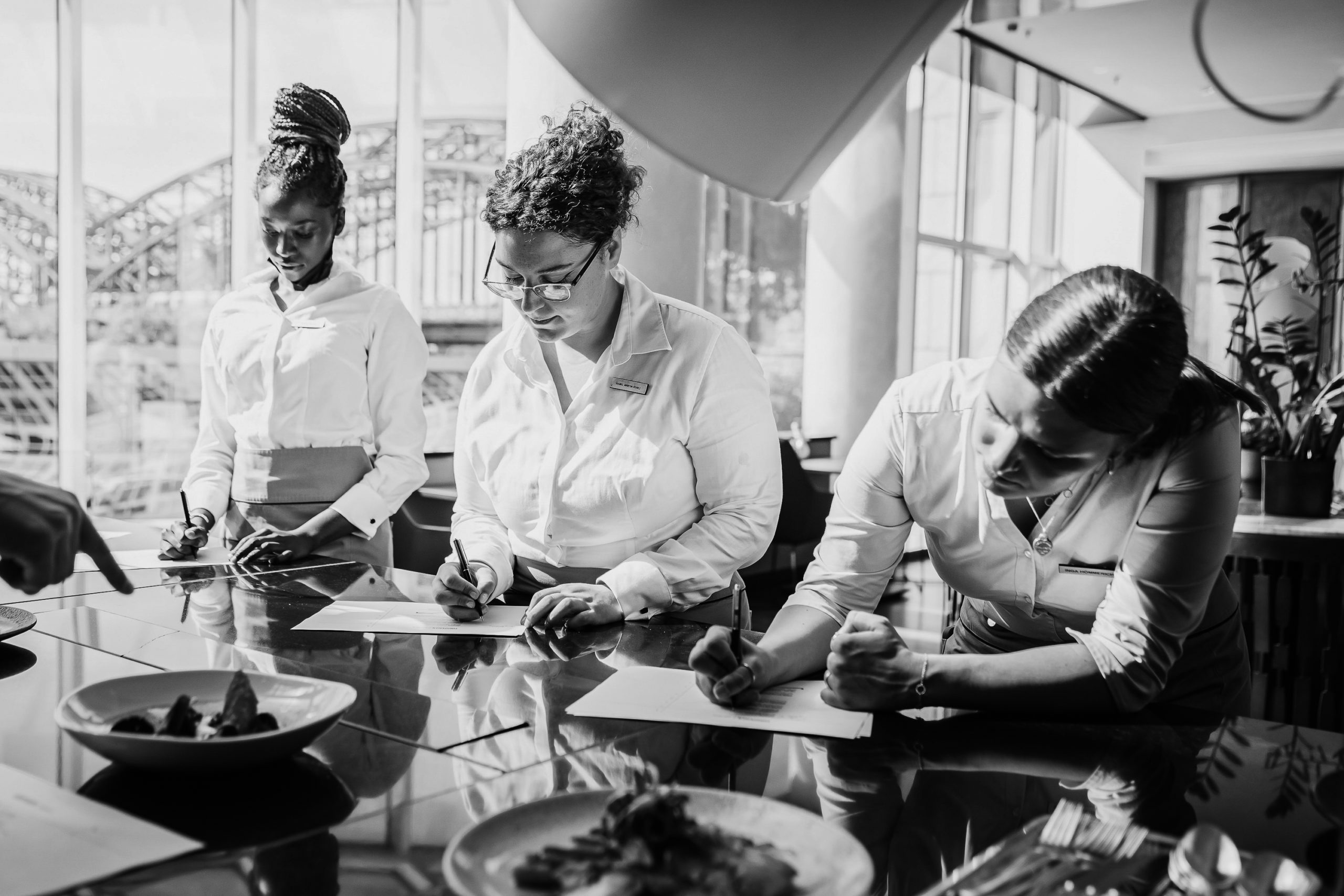 Service team writes notes for the menu in the Glashaus Restaurant Cologne. 